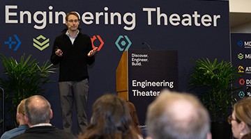 Attendees listen to the speaker on the Engineering Theater stage